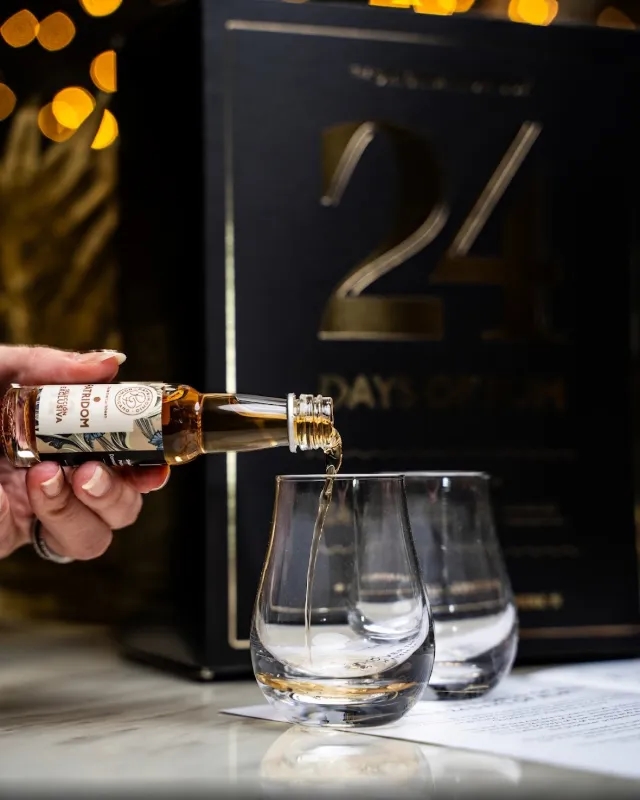 Miniatureflaske hældes op i to glas fra 24 Days of Rum Black Edition